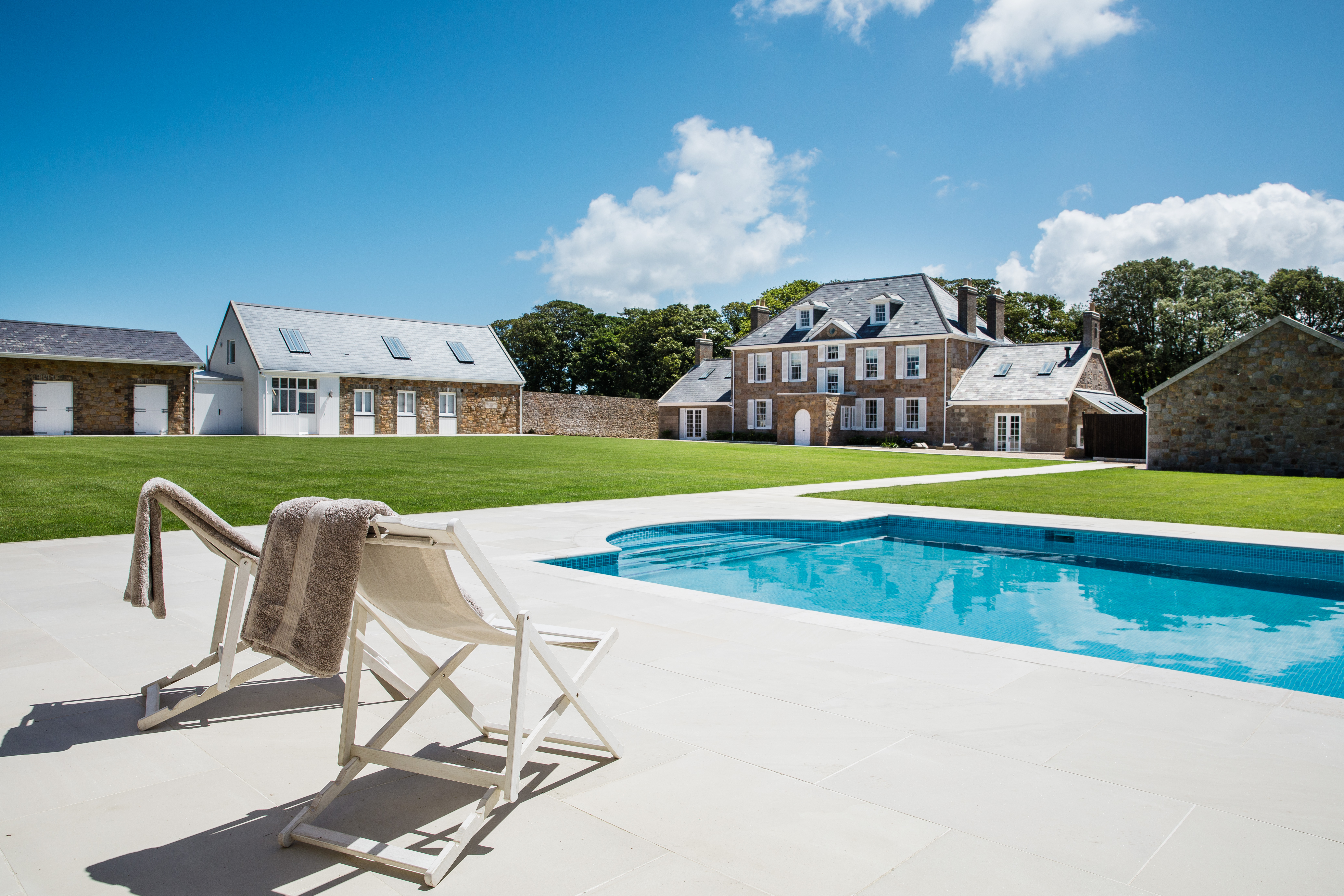Jersey converted farmhouse with a swimming pool and deck chairs