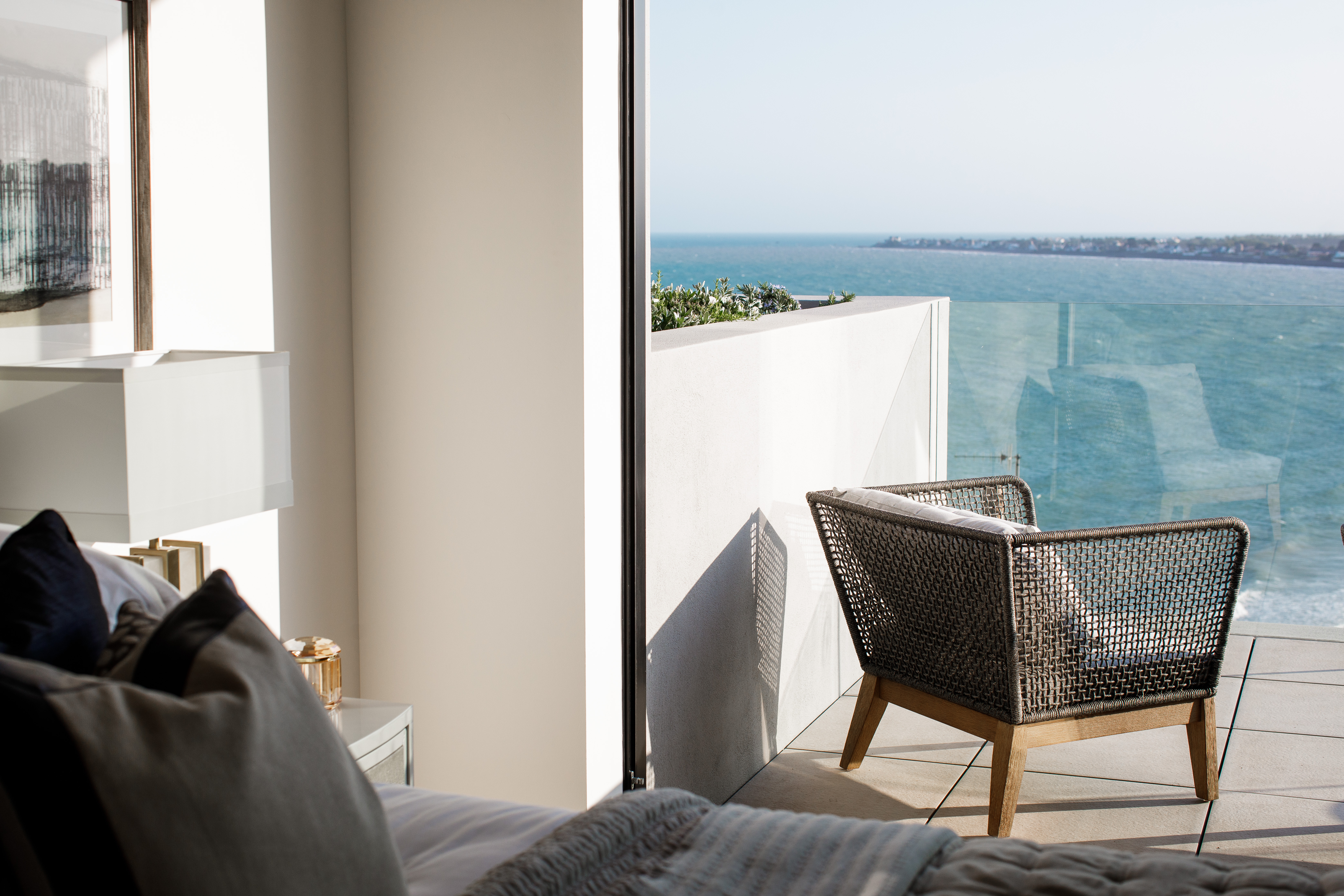 Chair on a balcony off the bedroom, looking out to the sea