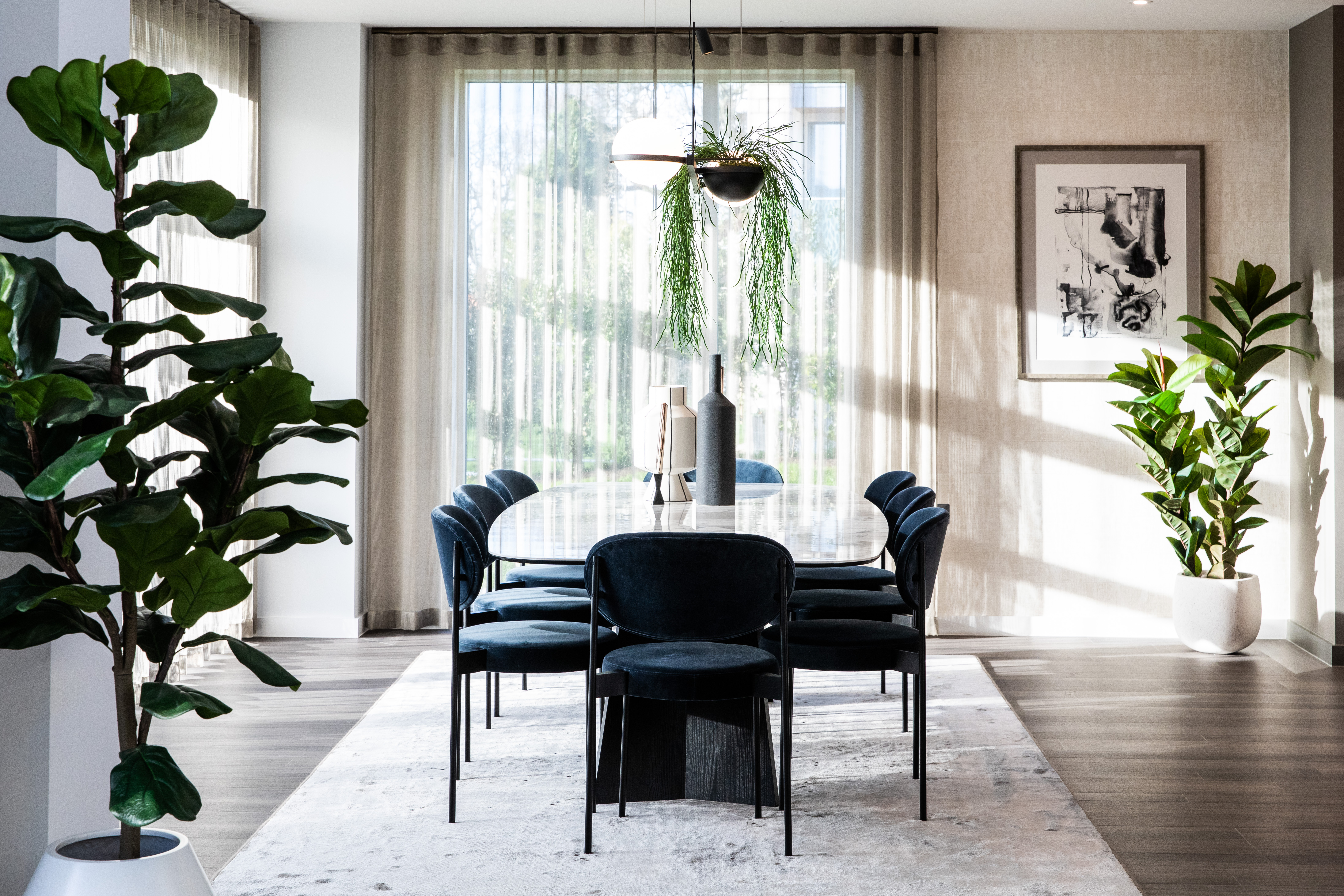 Modern dining room with a stylish table, chairs and surrounded by green plants